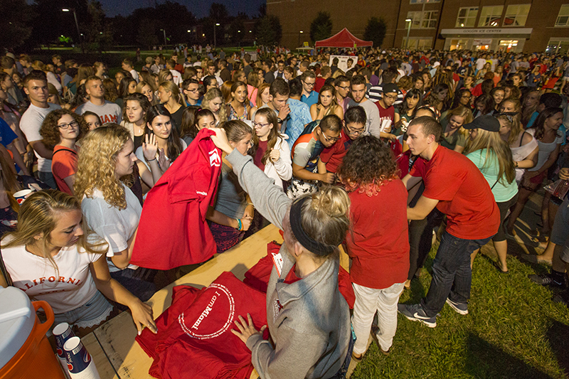 Students line up as staff passes out free t-shirts to a crowd of first-years